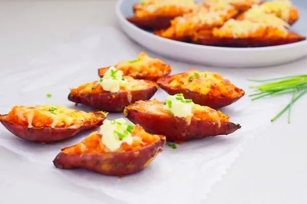 Loaded sweet potato on parchment paper and some on a plate