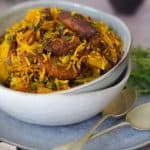 Soya Prawn Pilaf in a white bowl with 2 spoons on right and raita back right