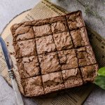 Easy Chocolate Brownies on a piece of brown paper on a wooden board
